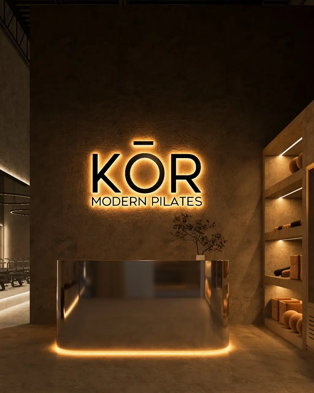 Sleek reception area of KōR Modern Pilates studio with illuminated logo, minimalist decor, and ambient lighting