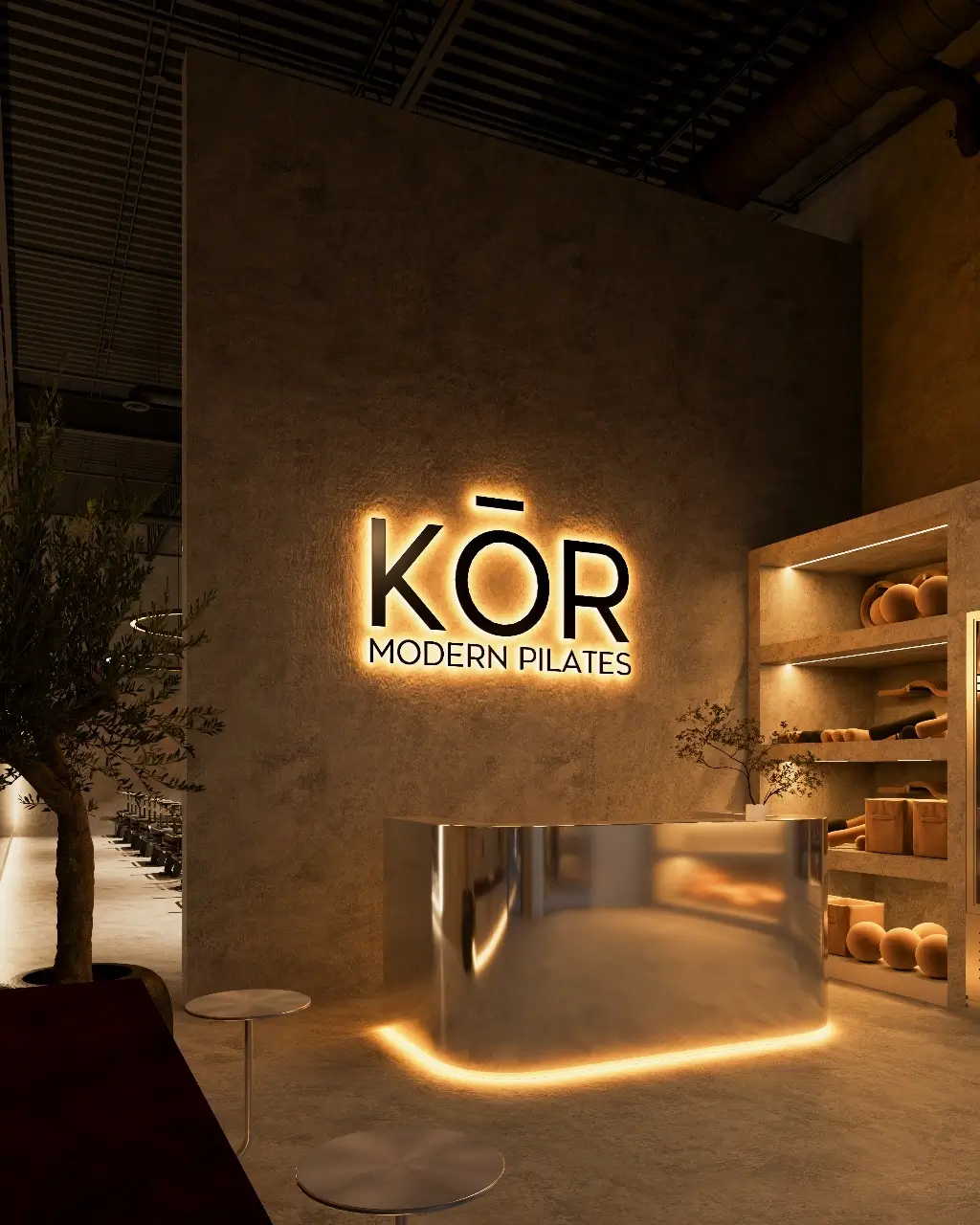 Sleek reception area of KōR Modern Pilates studio with illuminated logo, minimalist decor, and ambient lighting